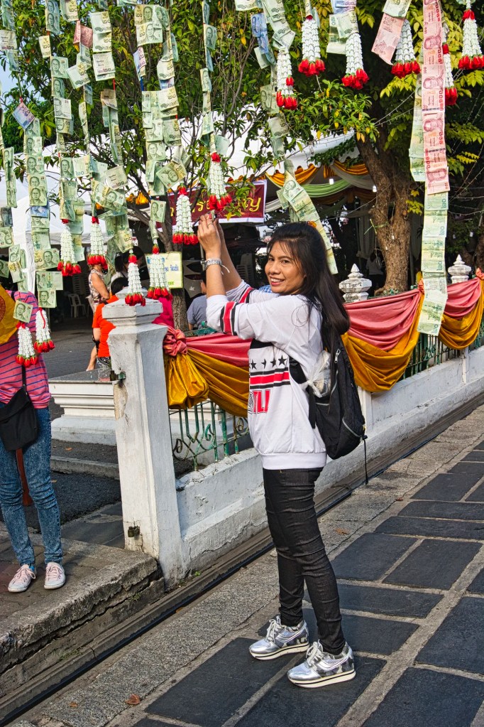 Woman adding Bahts to Money Tree, Wat Po, Bangkok